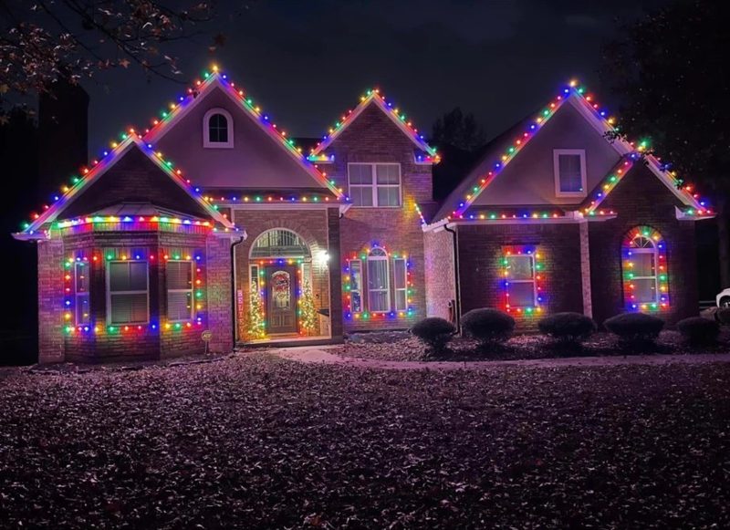 Multicolor bulbs on every gable, window and bay of a large brick home